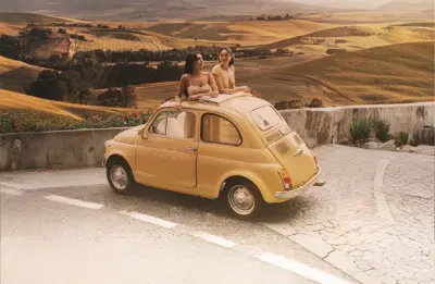Reisende mit Koffer vor einer italienischen Hotelkulisse und Kartenmotiv