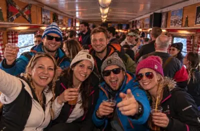 Nachtzug mit Partywagen und Schlafabteilen vor verschneiten Alpen